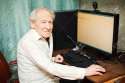 12537790-smiling-old-man-holding-computer-mouse-he-is-working-on-a-desktop-Stock-Photo.jpg