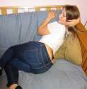 Mal Malloy white shirt jeans bac thong laying on side on couch.jpg