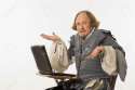 2145480-William-Shakespeare-in-period-clothing-sitting-in-school-desk-with-laptop-computer-shrugging-at-view-Stock-Photo.jpg