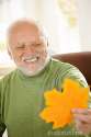 smiling-old-man-looking-yellow-leaf-16618138.jpg