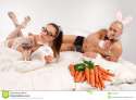 lovely-couple-rabbit-costume-lying-bed-glass-red-wine-carrots-30149550.jpg