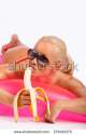 stock-photo-sexy-blond-girl-in-sunglasses-and-banana-posing-on-pink-water-mattress-273452375.jpg