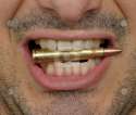 1376193523_cutcaster-photo-100757855-Bullet-between-teeth[1].jpg