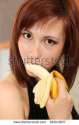 stock-photo-picture-of-young-woman-eating-banana-66043627.jpg