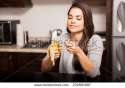 stock-photo-pretty-young-brunette-peeling-a-banana-before-eating-it-while-sitting-in-the-kitchen-232801687.jpg