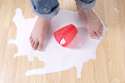 25993396-Child-feet-standing-in-puddle-of-spilled-milk-on-wood-floor-with-red-cup-Stock-Photo.jpg