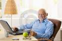 portrait-happy-senior-man-computer-sitting-desk-using-laptop-home-smiling-camera-33471654.jpg