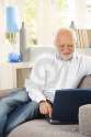 cheerful-pensioner-using-laptop-couch-27720797.jpg