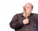 15869786-Fat-obese-man-enjoying-a-a-long-colourful-striped-lollipop-standing-licking-it-with-a-look-of-comple-Stock-Photo.jpg
