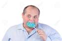 15200451-Fat-Man-in-a-Blue-Shirt-Eating-a-Lollipop-isolated-Stock-Photo.jpg