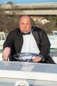 19340387-Overweight-man-in-a-tuxedo-at-the-helm-of-a-pleasure-boat-closeup-Stock-Photo.jpg
