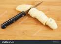 stock-photo-knife-cutting-banana-on-wooden-background-94525729.jpg