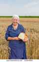 stock-photo-old-woman-is-holding-the-bread-in-a-field-of-mature-wheat-310679804.jpg