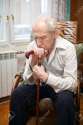 12537801-sad-lonely-old-man-sitting-in-an-armchair-with-his-cane-Stock-Photo.jpg