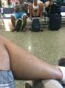 candidfashion girl at airport sitting on bench legs spread wide oblivious.jpg