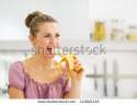 stock-photo-young-woman-eating-banana-in-kitchen-143921122.jpg