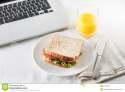 having-sandwich-orange-juice-as-snack-working-healthy-vegetable-glass-office-table-computer-31238480.jpg