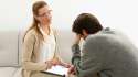 stock-footage-young-man-sitting-on-sofa-talking-to-his-therapist-at-therapy-session.jpg