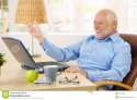 laughing-old-man-using-laptop-computer-home-looking-screen-gesturing-30317501.jpg