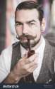 stock-photo-handsome-big-moustache-hipster-man-smoking-pipe-in-the-city-234485653.jpg